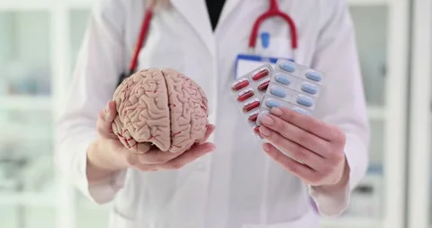 Doctor holding a brain model and pills Stock Footage 285017514