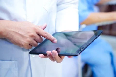 Doctor holding digital tablet technology to search knowledge solve treatment. Stock Photos