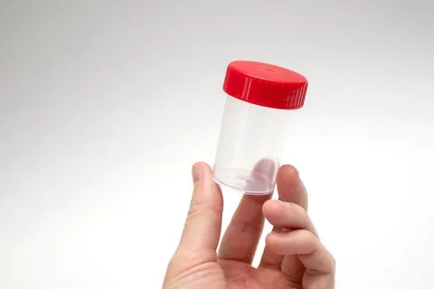 Doctor holding empty sample cup. Plastic container for medical tests. Stock-Fotos
