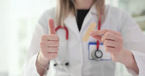 Doctor holding a patch and showing thumbs up in clinic Stock Footage 285374363