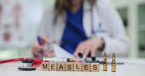 Doctor holds pen and document with word Measles on wooden blocks Stock Footage 313294152