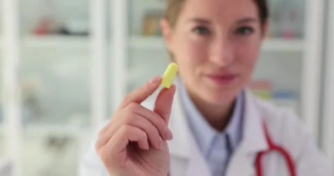 Doctor inserts earplug into ear to minimize noise level Stock Footage 278670713