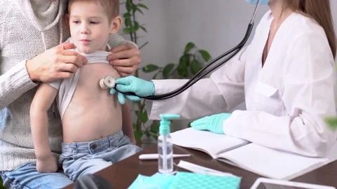 Doctor is inspectioning a boy patient while listening to him using a stethoscope Stock-Footage 194465654