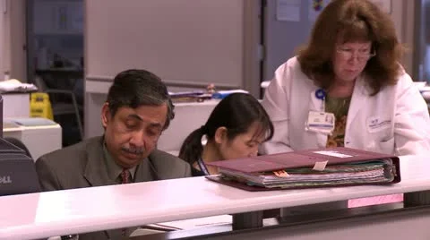 Doctor interacting with Nurses at counter Stock Footage 10903150