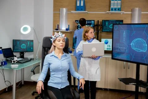 Doctor introducing some data into the laptop during a girl's brain scan Stock-Fotos