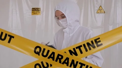 Doctor in a lab behind a warning tape, holding a clipboard and making notes. Video stock 139859908