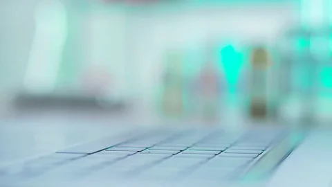 The doctor in the lab typing on notebook report on his research Stock Footage 82997345