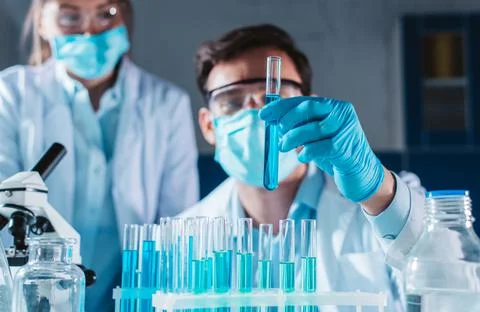 Doctor in the laboratory analyzes samples of codiv-9 under a microscope Stock Photos