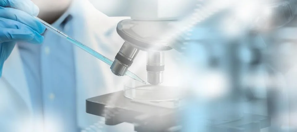 Doctor in a laboratory with a microscope liquid sample beneath microscope o.. Stock-Fotos