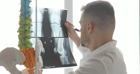 Doctor is learning bones on x-ray images standing near the window. Stock Footage 108020954