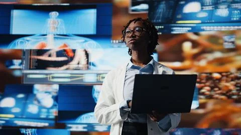 Doctor looking at genomes on notebook screen, comparing infection models Stock Photos