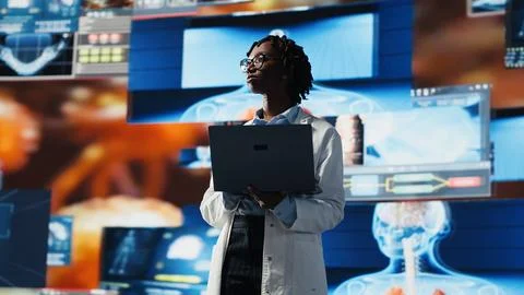 Doctor looking at genomes on notebook screen, comparing infection models Stock Photos