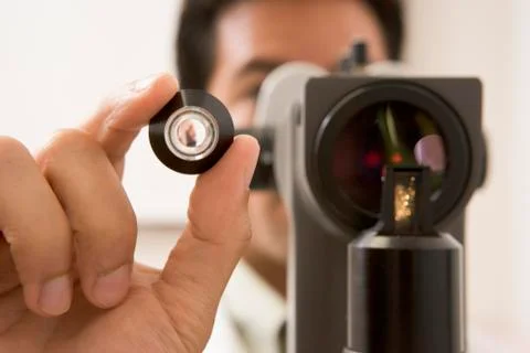 Doctor Looking Through Eye Exam Machine Stock Photos