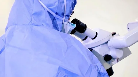 Doctor is Looking Through surgery Microscope Stock Footage 104251002