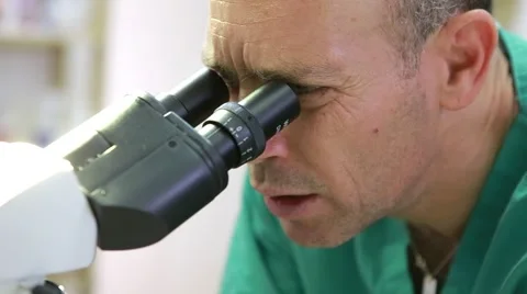 Doctor looks into microscope close up Stock Footage 62834129