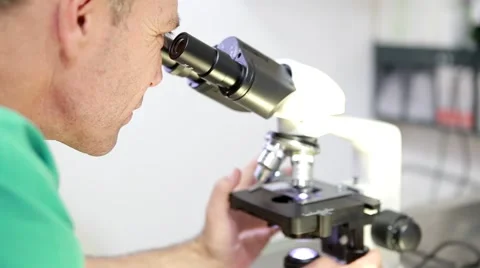 Doctor looks into microscope Vidéo 62834756