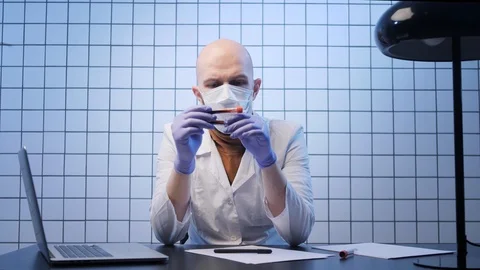 Doctor looks at samples of coronavirus at table in lab Stock Footage 127214873