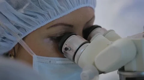 Doctor looks through a microscope during surgery, microsurgery, NATURAL GRADE Stock Footage 51445743