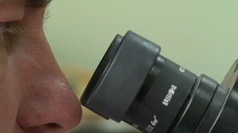 Doctor looks through a microscope 스톡 동영상 12472834