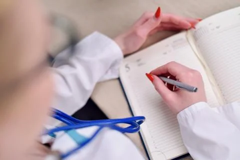 The doctor makes notes in the diary Stock Photos