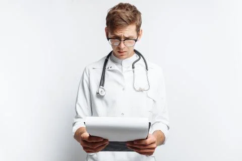 The doctor makes notes in the documents, a young student with a folder in his Stock Photos