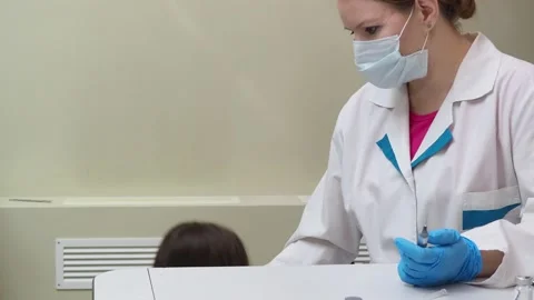 A doctor makes a syringe inoculation for a small child against colds 库存影片 151780170
