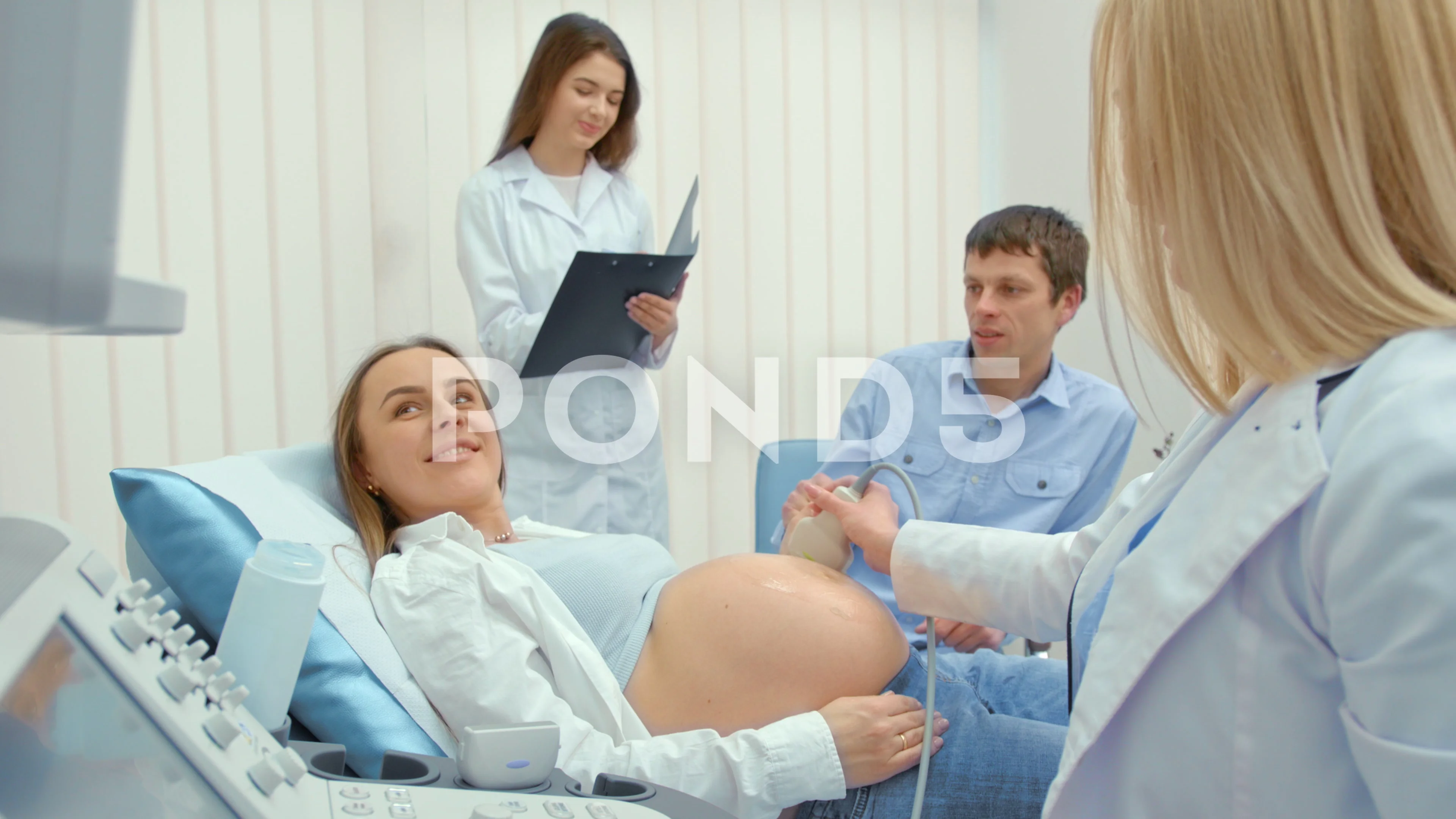 The doctor makes an ultrasound scan for a pregnant woman in a hospital