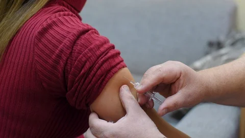 Doctor makes vaccination in the woman's hand. Injection of a syringe in the Stock Footage