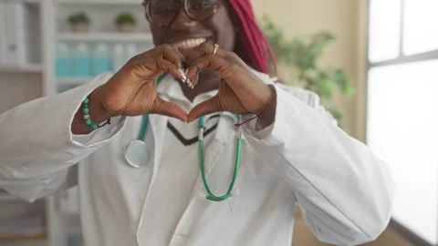 Doctor making heart shape with hands, embodying compassion in a hospital se.. Vídeos de archivo 310473052