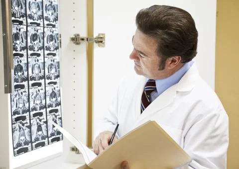 Doctor Making Notation in Chart Stock Photos