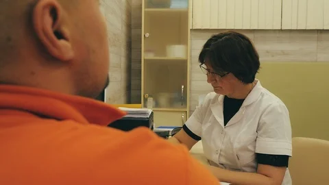 Doctor is making notes after conversation with her client. Stock Footage 124468120