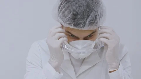 Doctor man getting ready puts on mask and glasses Stock Footage 129853516