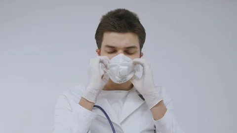 Doctor man getting ready puts on mask and glasses 動画素材 129854453