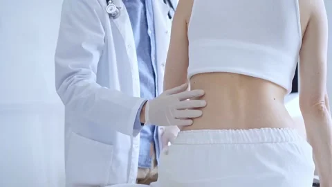 Doctor man is making notes on a clipboard while patient woman is describing back Stock Footage 281414115
