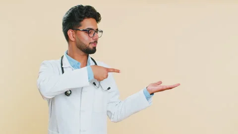 Doctor man showing thumbs up and pointing on blank space place for advertisement 動画素材 252152298