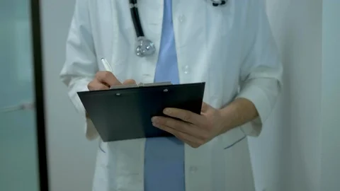 Doctor man writing prescription close-up. Close-up Of Male Doctor Hand Filling Stock Footage