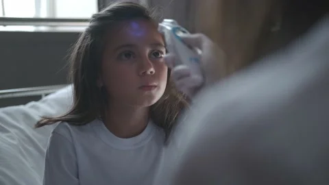 Doctor measures the temperature with electronic thermometer to a girl Stock-Footage 137327082