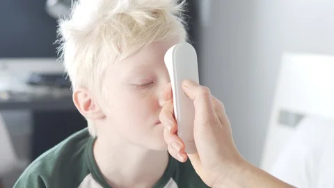 The doctor measures the temperature of a sick boy with an electronic thermometer Stock Footage 129240953
