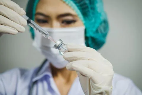 Doctor nurse holding syringe vaccine preparing for human clinical Stock Photos