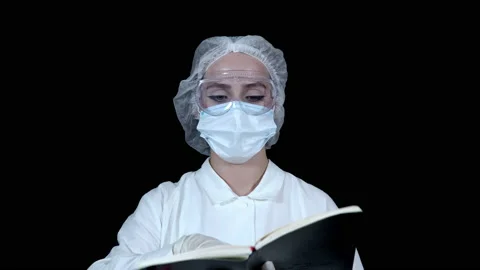 The doctor opens a work notebook, leafs through and looks for some kind of entry Stock Footage 141316284