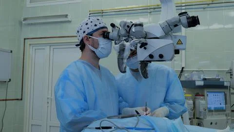The doctor operates using a microscope during nerve surgery. The surgeon looks Stock Photos