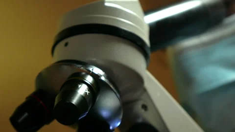 Doctor or Laboratory Technician Looking Through Microscope in Medical Laboratory Stock Footage 328929764