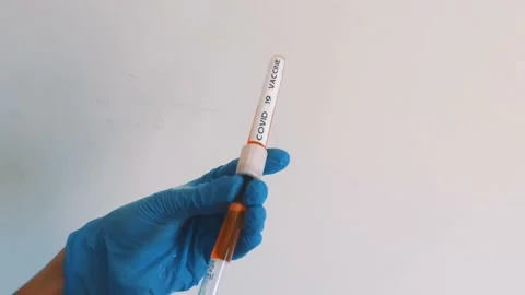 Doctor or nurse with the Covid-19 vaccine holding it in their hands with nitrile Stock Footage
