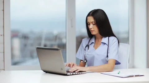 Doctor or nurse with laptop pc writing prescription Stock Footage