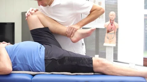 Doctor or physiotherapist performing hip mobility examination Stock Footage 58631953