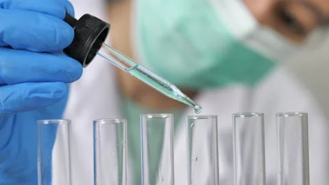 Doctor or scientist is using a test tube to drop a drop of liquid into a glas Video stock 157866261