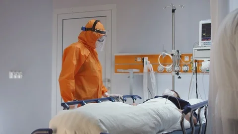 Doctor in Orange Protective Suit Checking on Coronavirus Patient Stock Footage 126205825