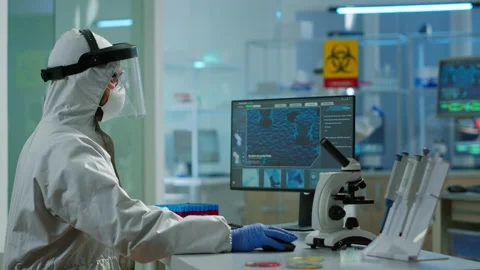 Doctor with overall suit working at computer and looking at camera. Stock Footage 147736691