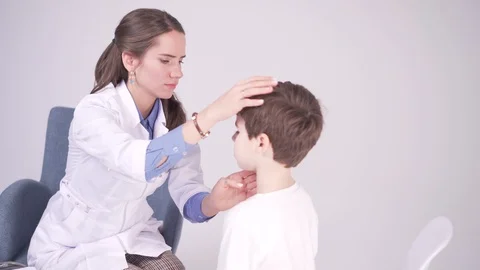 Doctor is palpating lymph node on the neck of 7 years old boy, medical checkup Stock Footage