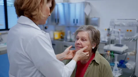Doctor palpating lymph nodes during medical examination of senior patient. Stock Footage 313791456